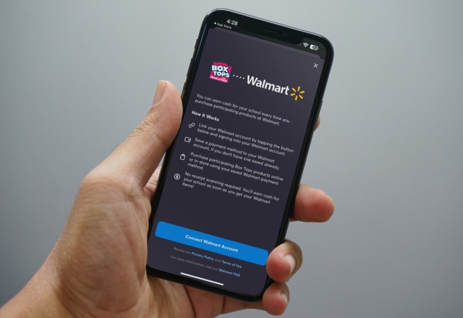 Hand holding a phone showing how to connect the Box Tops App with your Walmart account