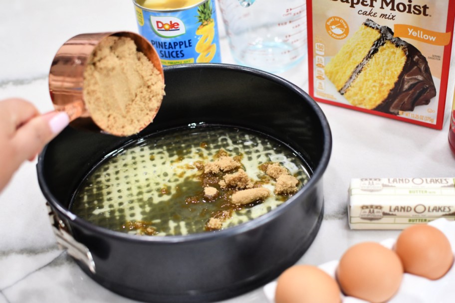 adding browned sugar to a springform cake pan