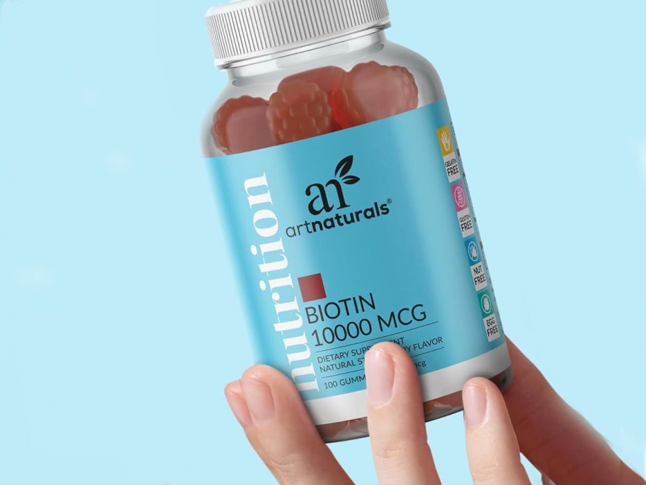 hand holding artnaturals biotin gummies bottle