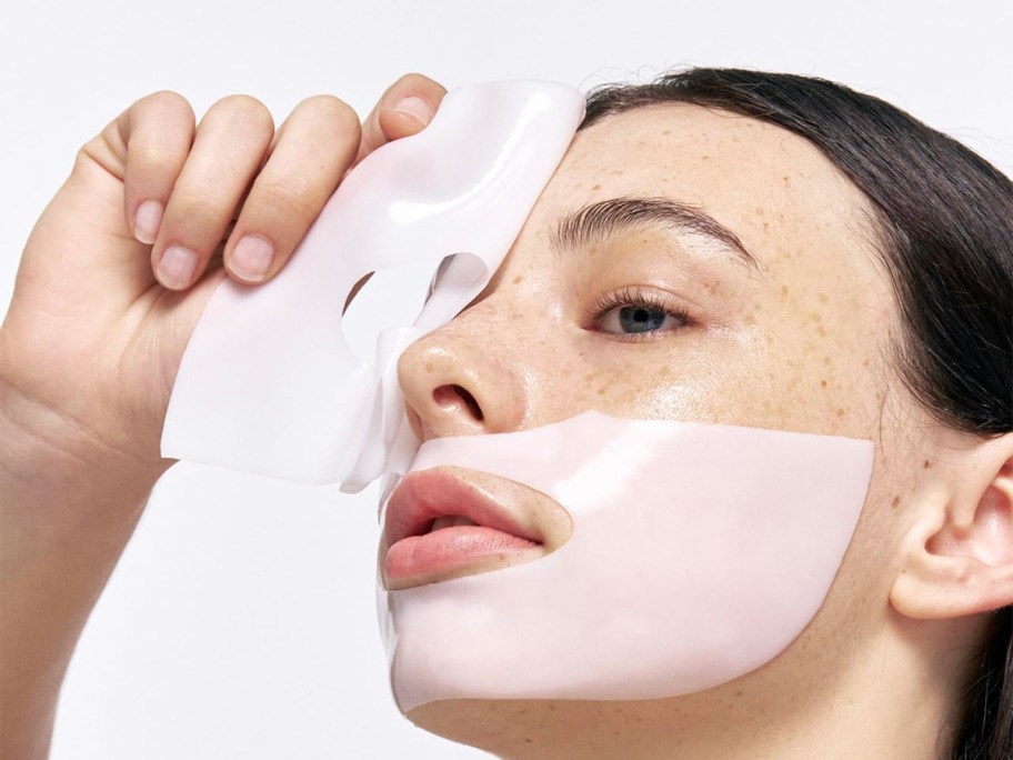 woman applying a white collagen mask