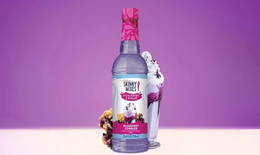 a bottle of flavored syrup shown with a blueberry drink
