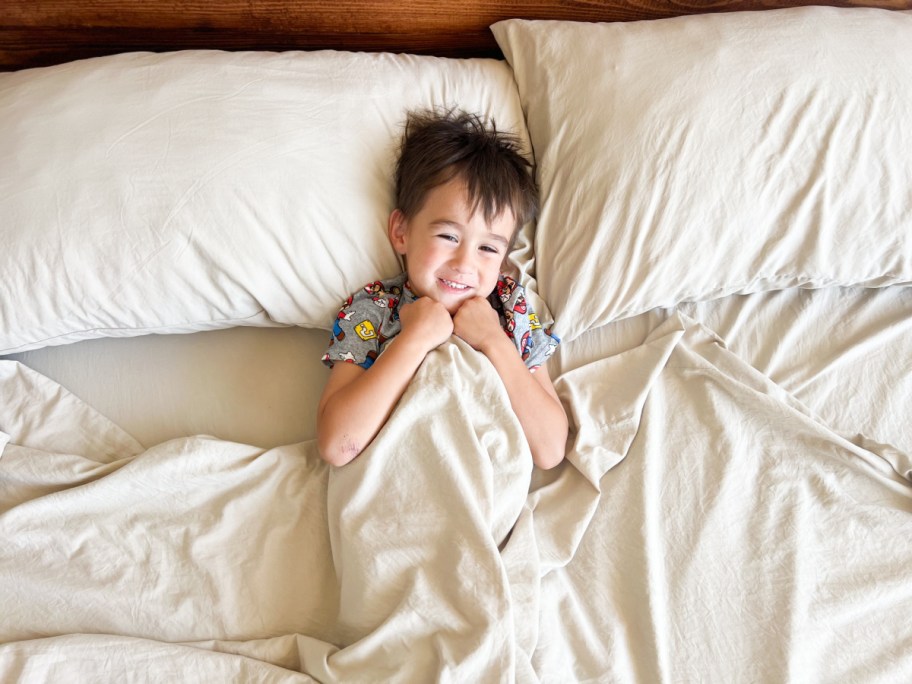 boy hugging bed sheets