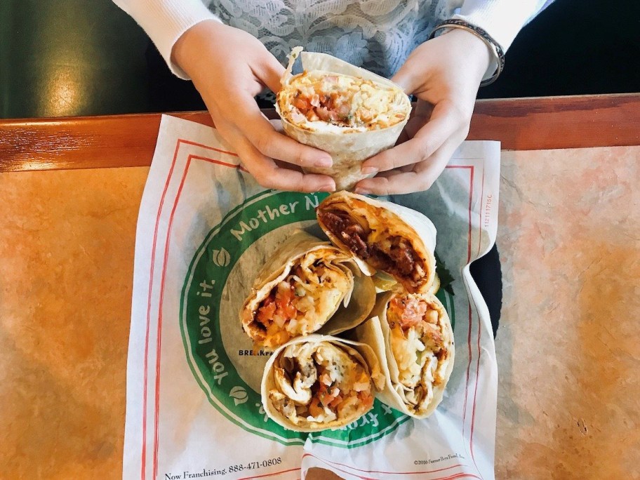 eating from a plate of breakfast burritos