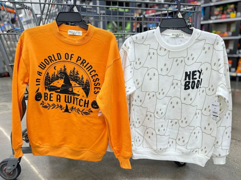 halloween sweatshirts hanging on cart in store