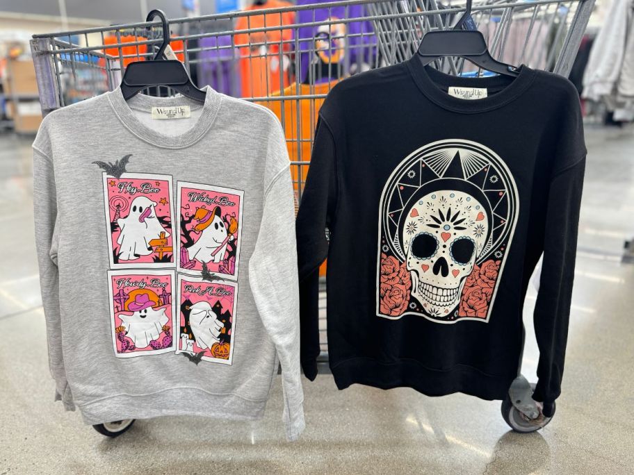 halloween sweatshirts hanging on cart in store