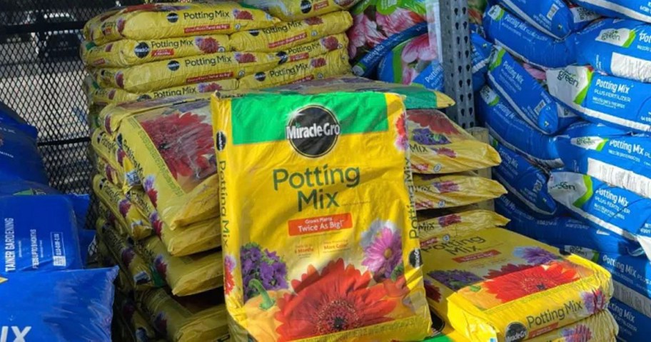 miracle gro potting mix bag sitting in front of stack of bags