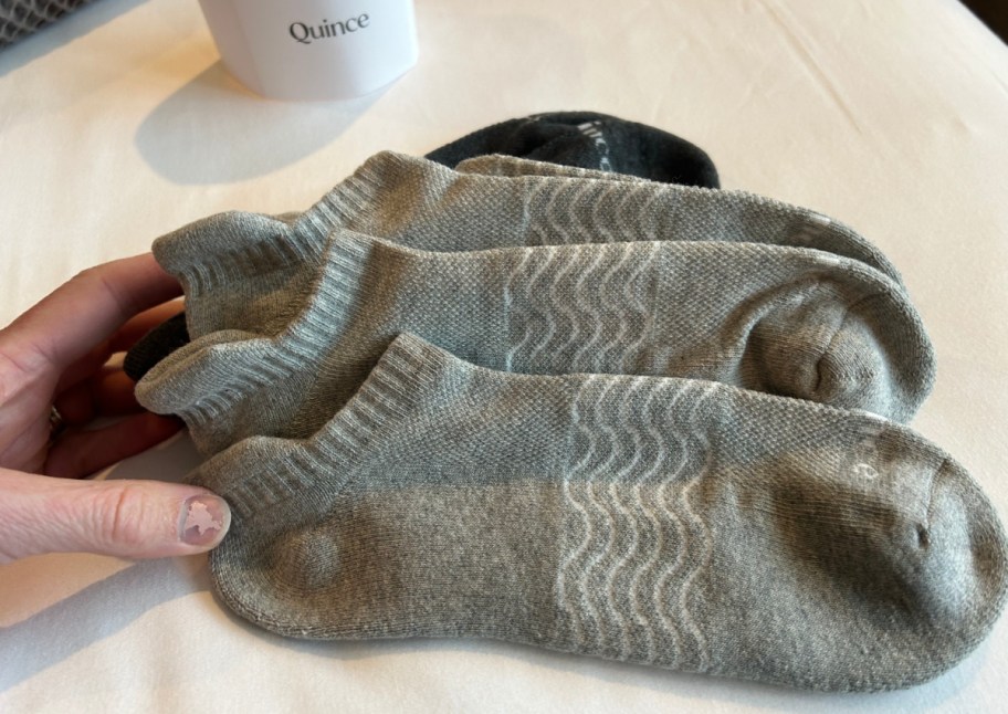 hand grabbing grey ankle socks