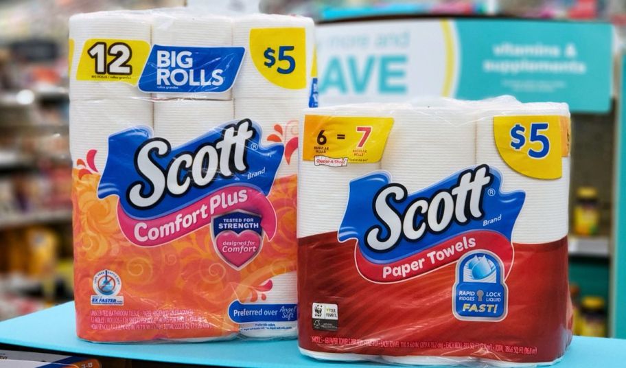 a twelve pack of scott comfort plus toilet paper and a 6 pack of scott paper towels on a store shelf