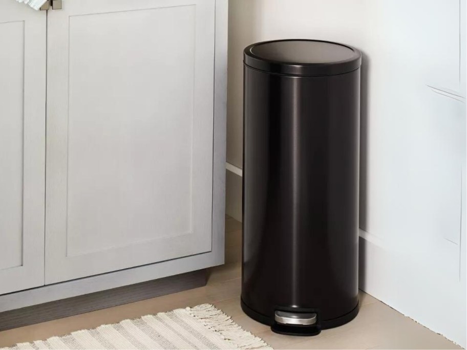 medium size round black metal step trash can in a kitchen