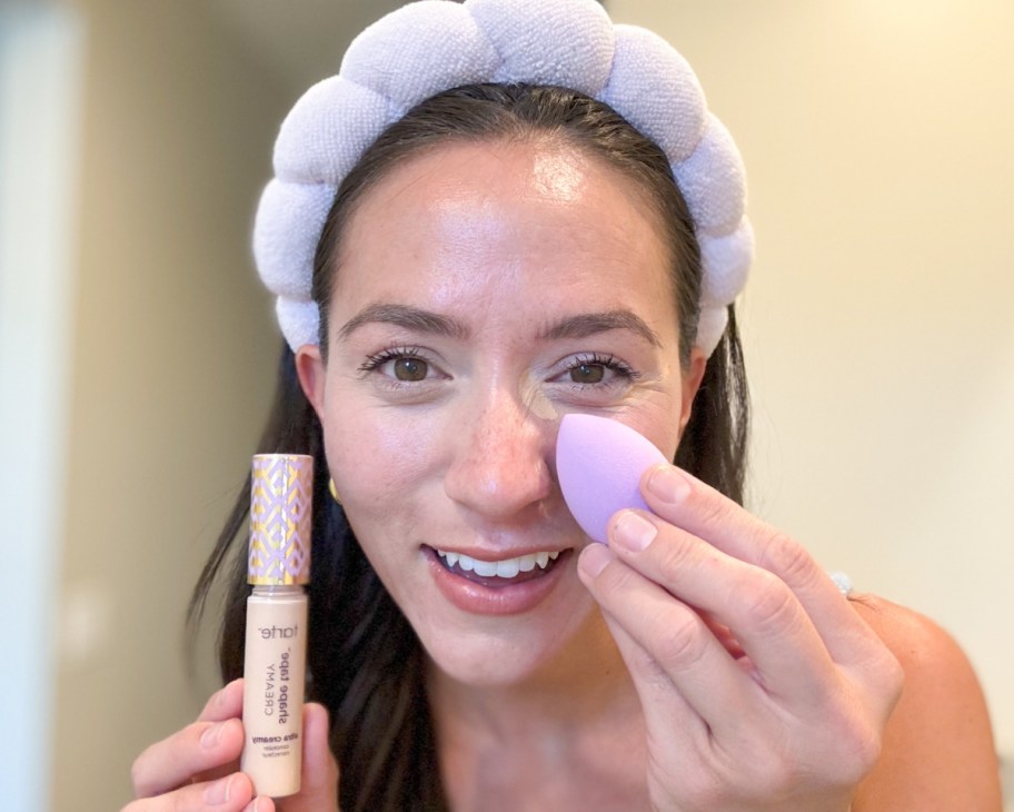 woman applying concealer with sponge