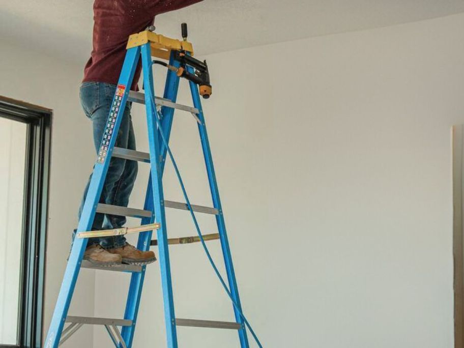 man on a blue and yellow ladder 