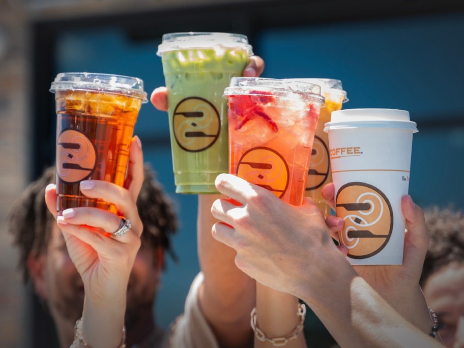 4 hands holding up beverages in Ziggi's coffee cups