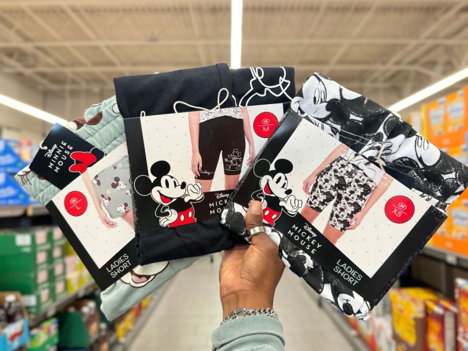 A hand holding 3 Aldi Disney Ladies Shorts