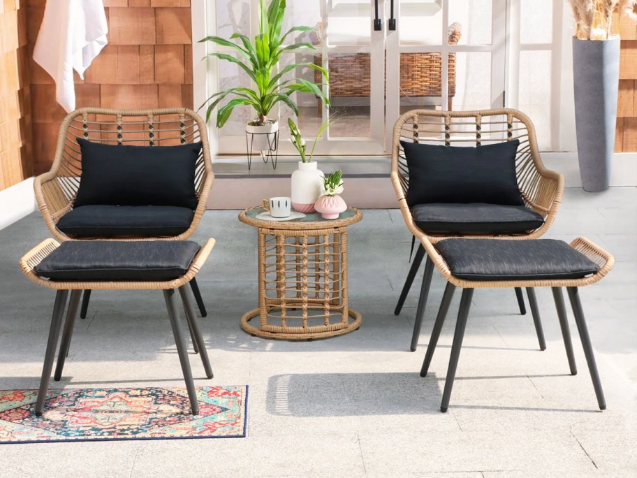 patio chairs with black cushions and matching ottomans and side table
