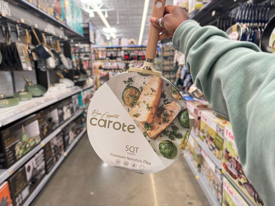 A hand holding a Carote Bon Appétit Collection 5 QT Nonstick Sauté Pan in white