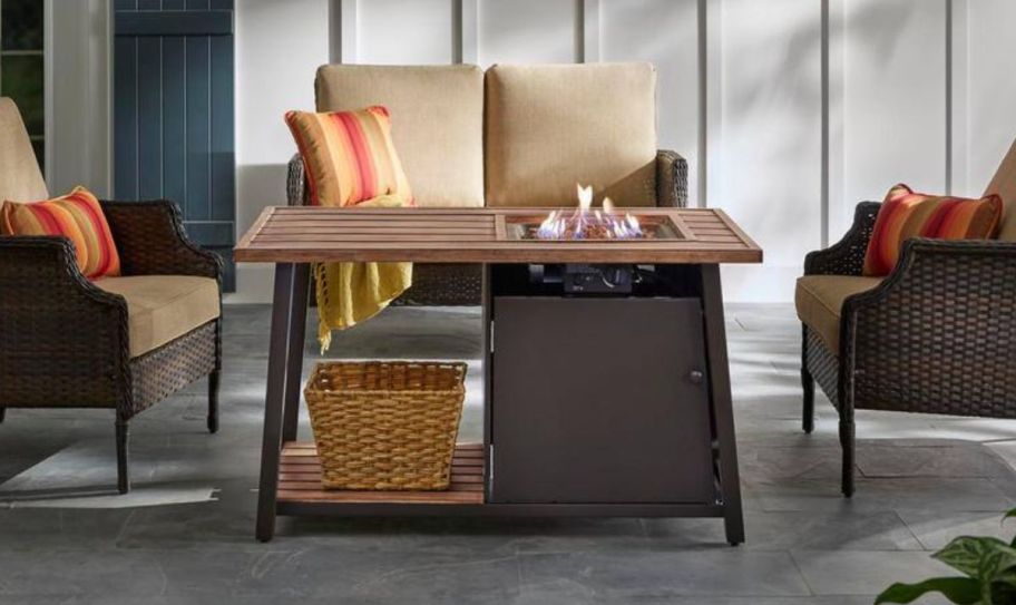 a fire pit coffee table on a patio displayed with patio furniture