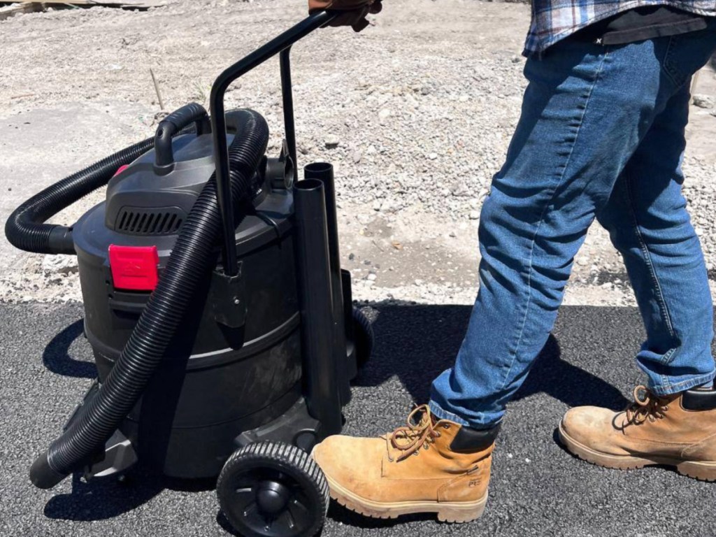 man pushing Husky Vacuum outside