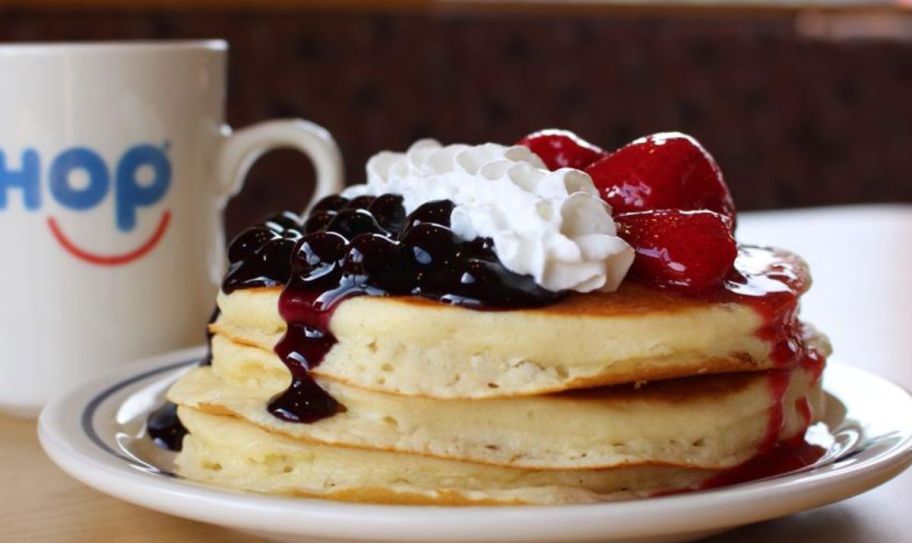 a plate of ihop red white and blueberry pancakes shown with a cup of coffee