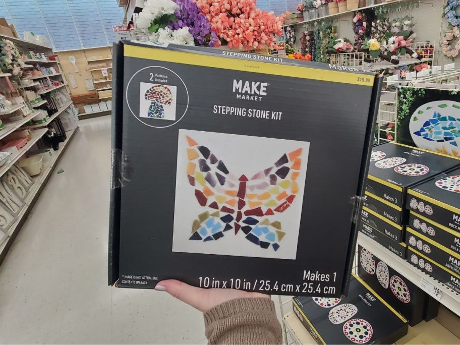 A hand holding a Make Market Butterfly Stepping Stones