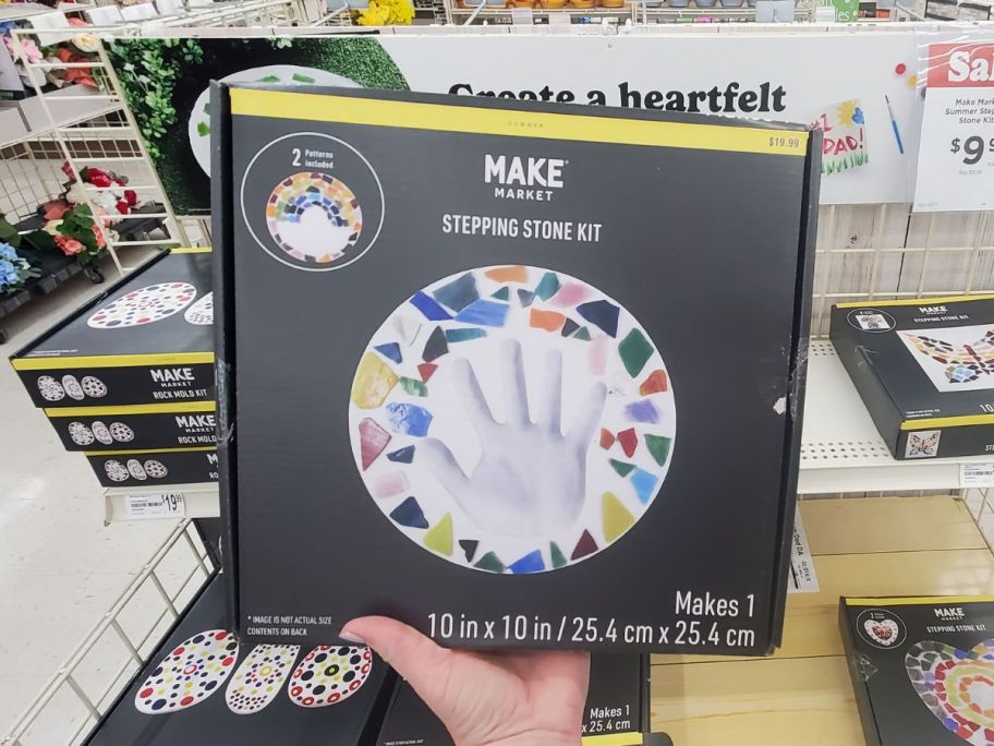 A hand holding a Make Market Hand Print Stepping Stones