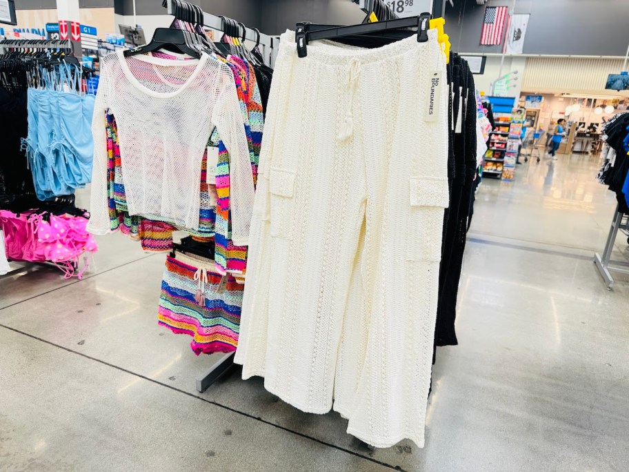 white crochet pants hanging from store rack
