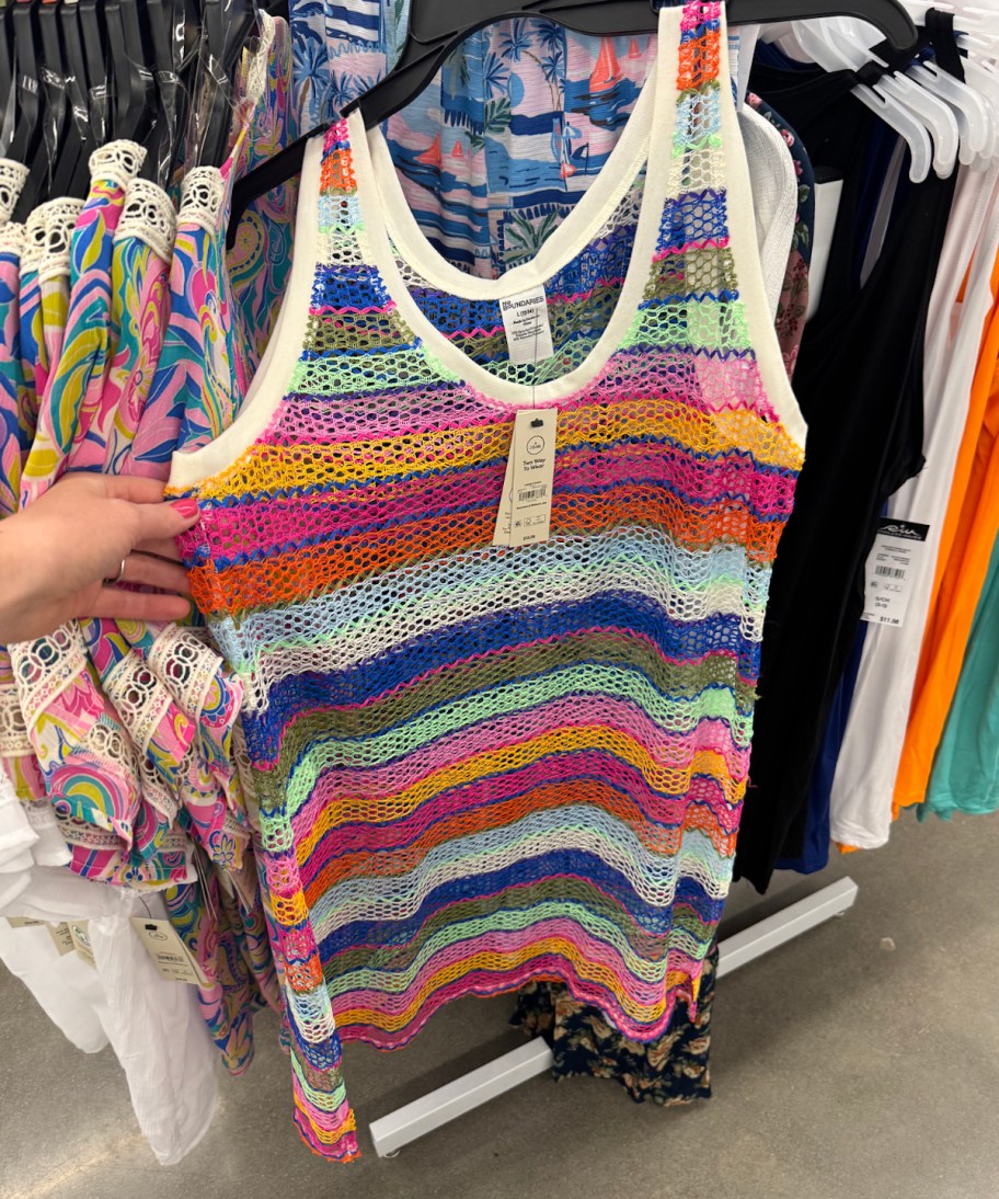 hand holding crochet striped cover up on store hanger