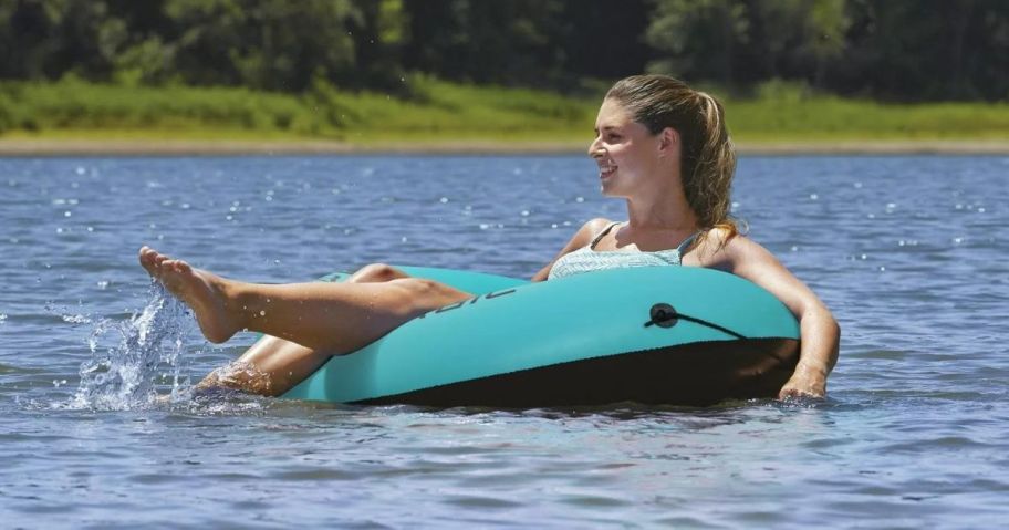 A woman floating on a tube in a lake