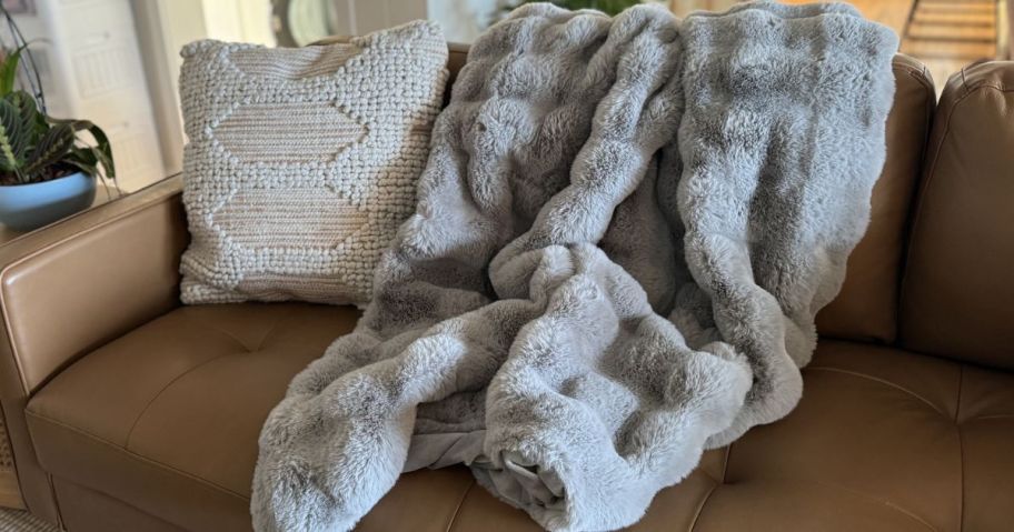 A quince faux fur throw draped over a couch