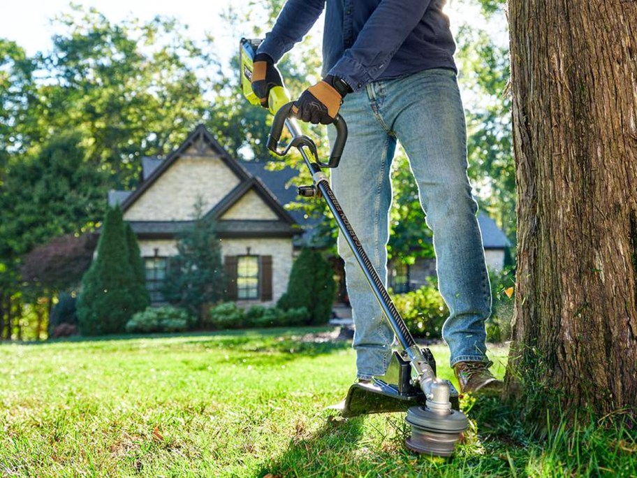 man using a black and green RYOBI Cordless String Trimmer
