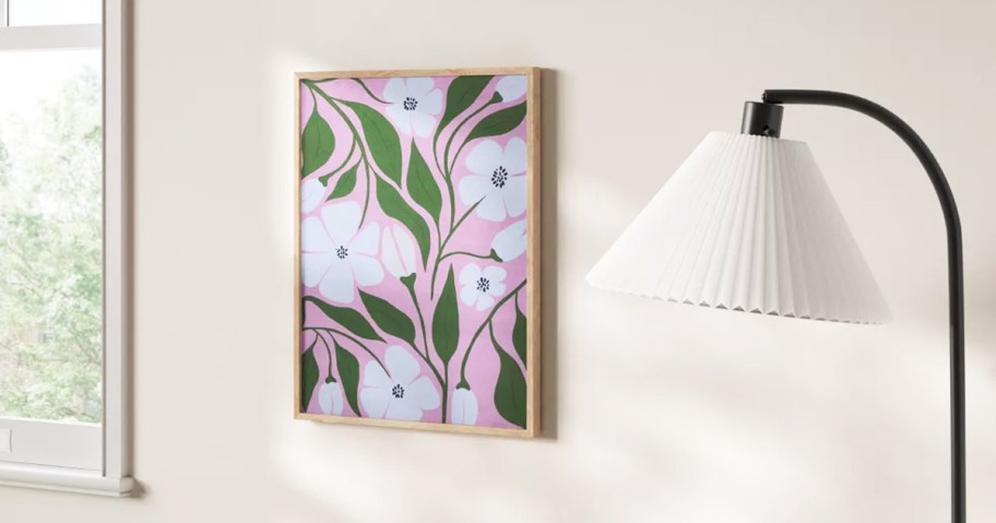 framed white flowers on pink background on wall near lamp