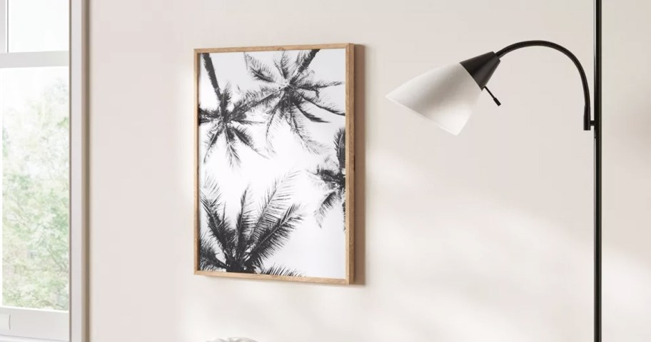 black and white framed palm trees print on wall near lamp