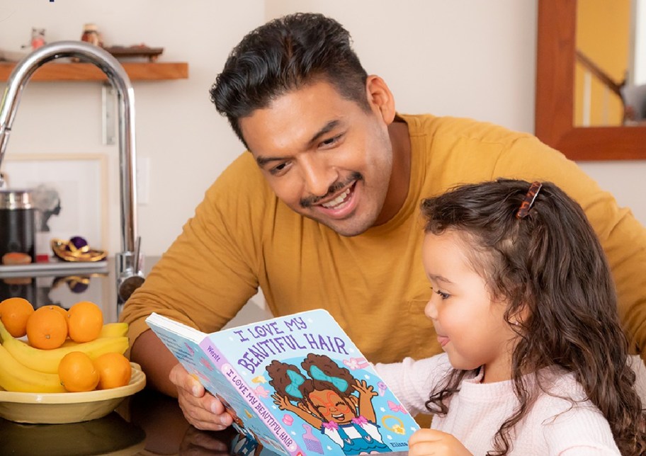 Girl and dad reading a book as part of the Scholastic summer reading program for kids