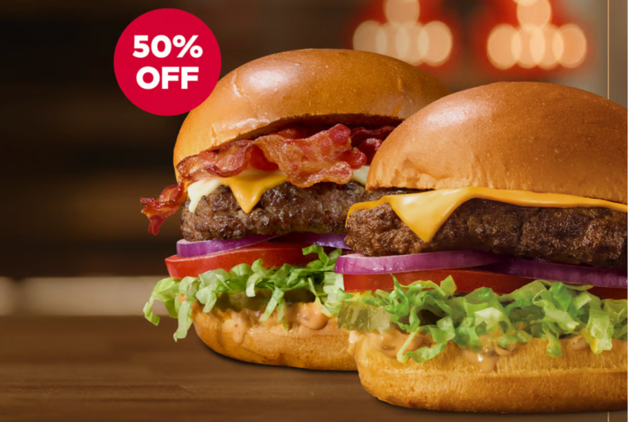 bacon cheeseburger and regular cheeseburger sitting on table