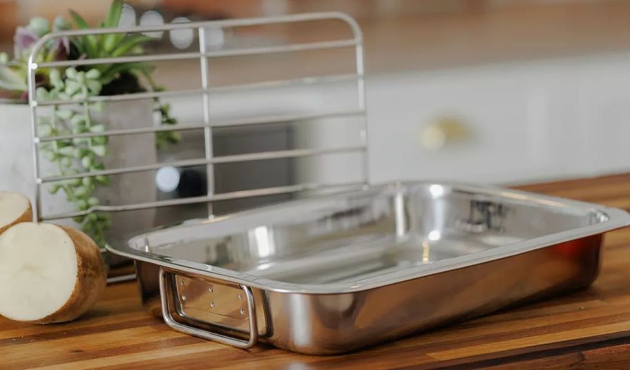 a stainless steel roasting pan and rack on a butcher block