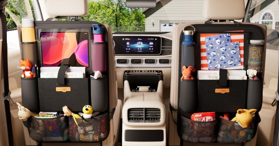 inside of a car with brown leather seats, showing black car seat organizers with a a variety of items in them