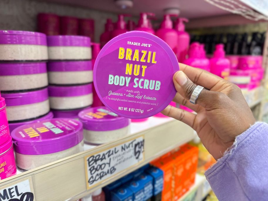 A hand holding a Trader Joe's Brazil Nut Body Scrub