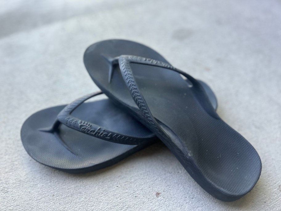 pair of black flip flops on porch