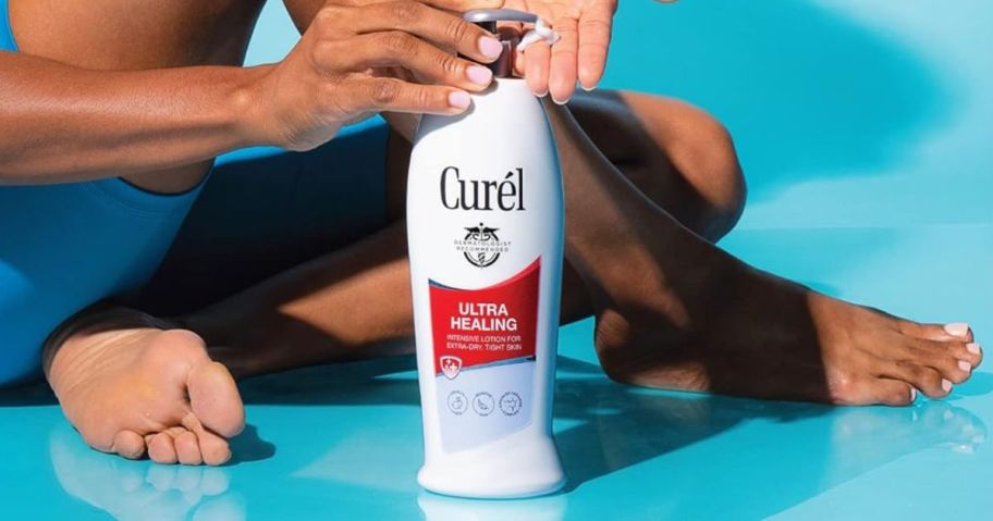 woman sitting next to a bottle of Curel lotion