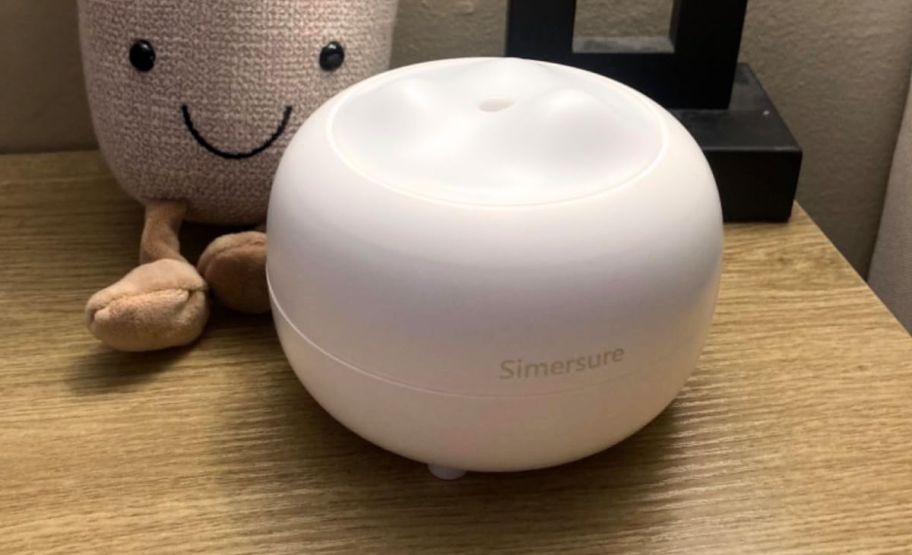 a white essential oil diffuser on a bedside table
