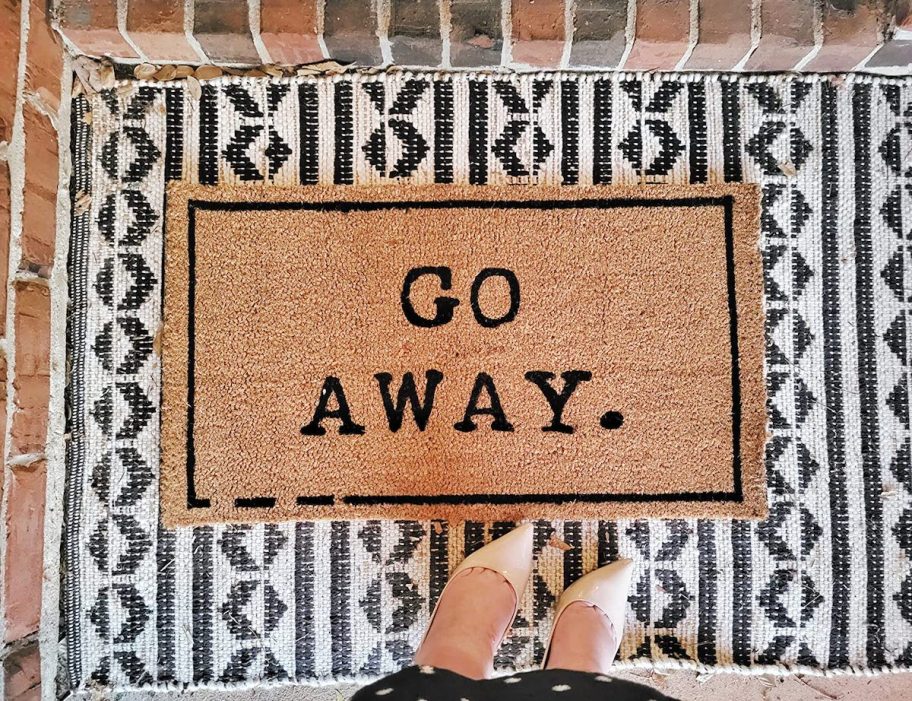 go away doormat on black and white geometric rug