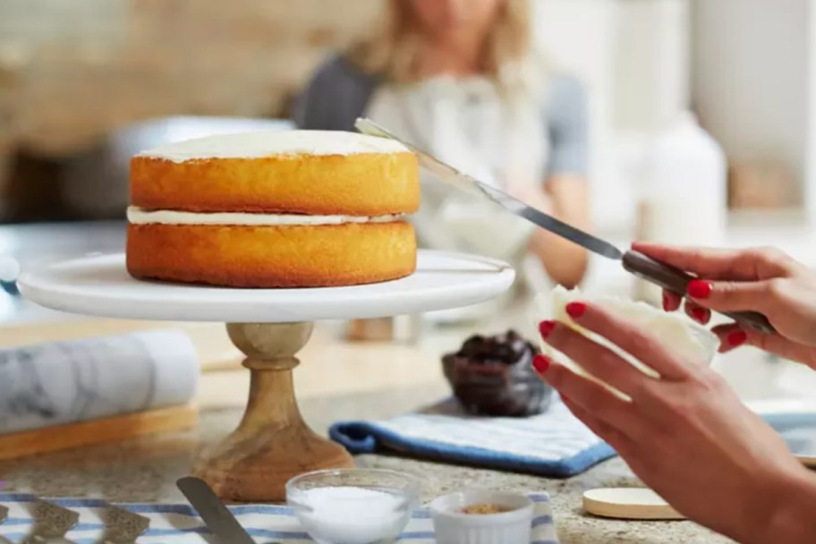 hands decorating a cake