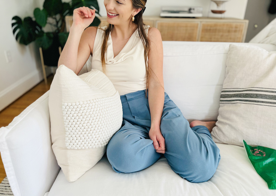 woman sitting on white couch smiling wearing halara waffle pants