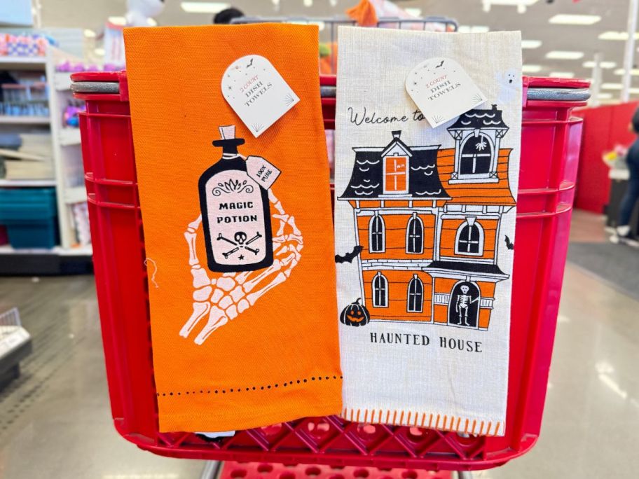 2 halloween themed dish towels hanging on a target cart