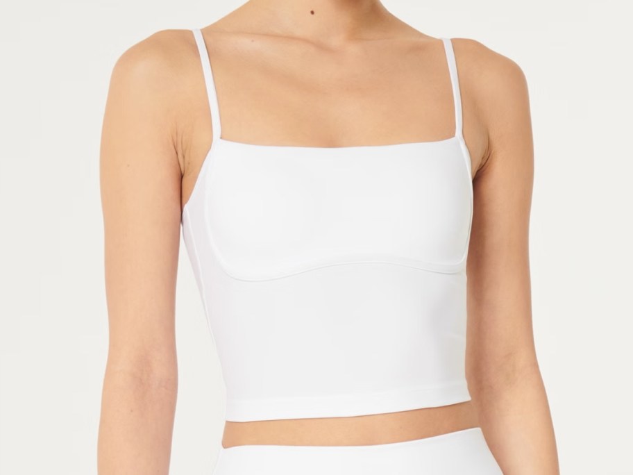 woman wearing a white under bust style activewear tank top