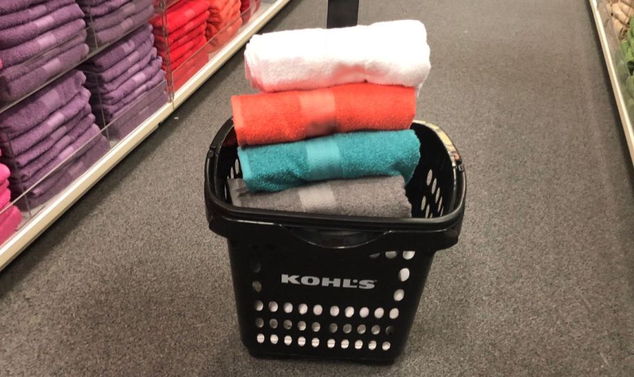 a stack of bath sheets in a shopping basket in a Kohl's store