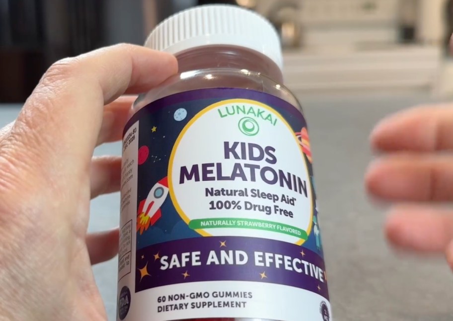 hands holding melatonin gummy jar