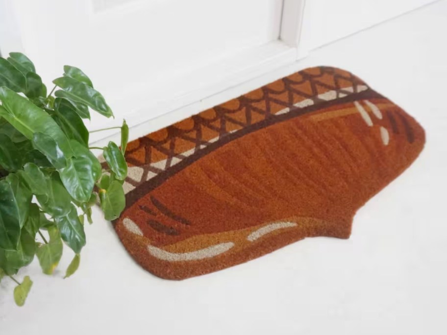a brown acorn shaped coir doormat in front of a white door
