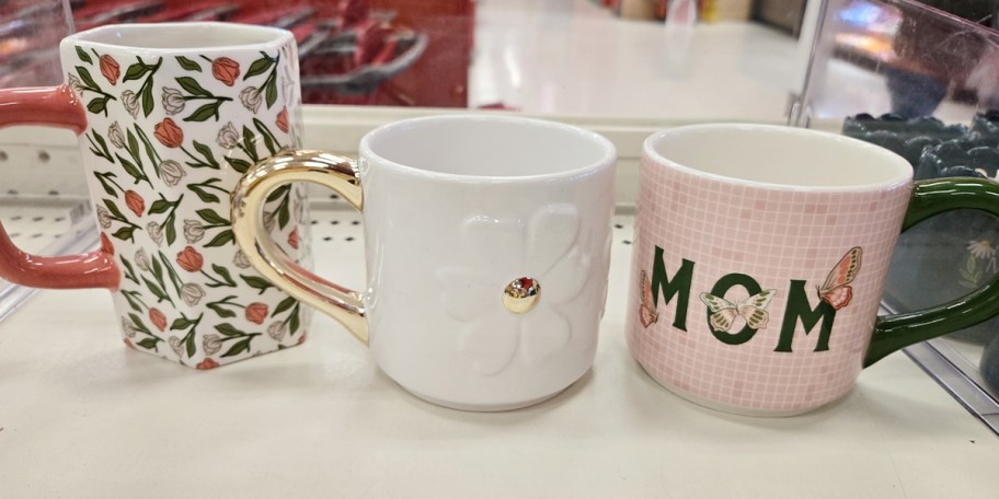 floral, daisy and mom mugs on shelf 