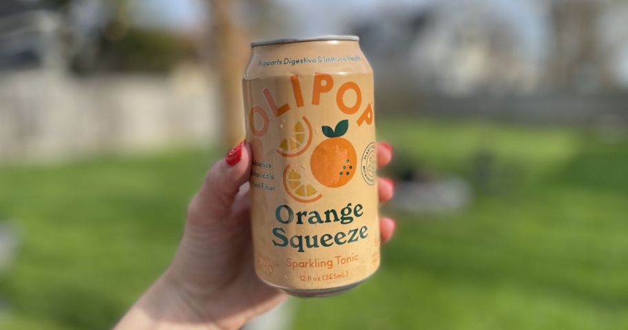 hand holding olipop soda can outside