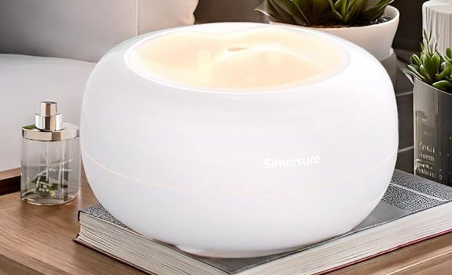 a white essential oil diffuser on a bedside table